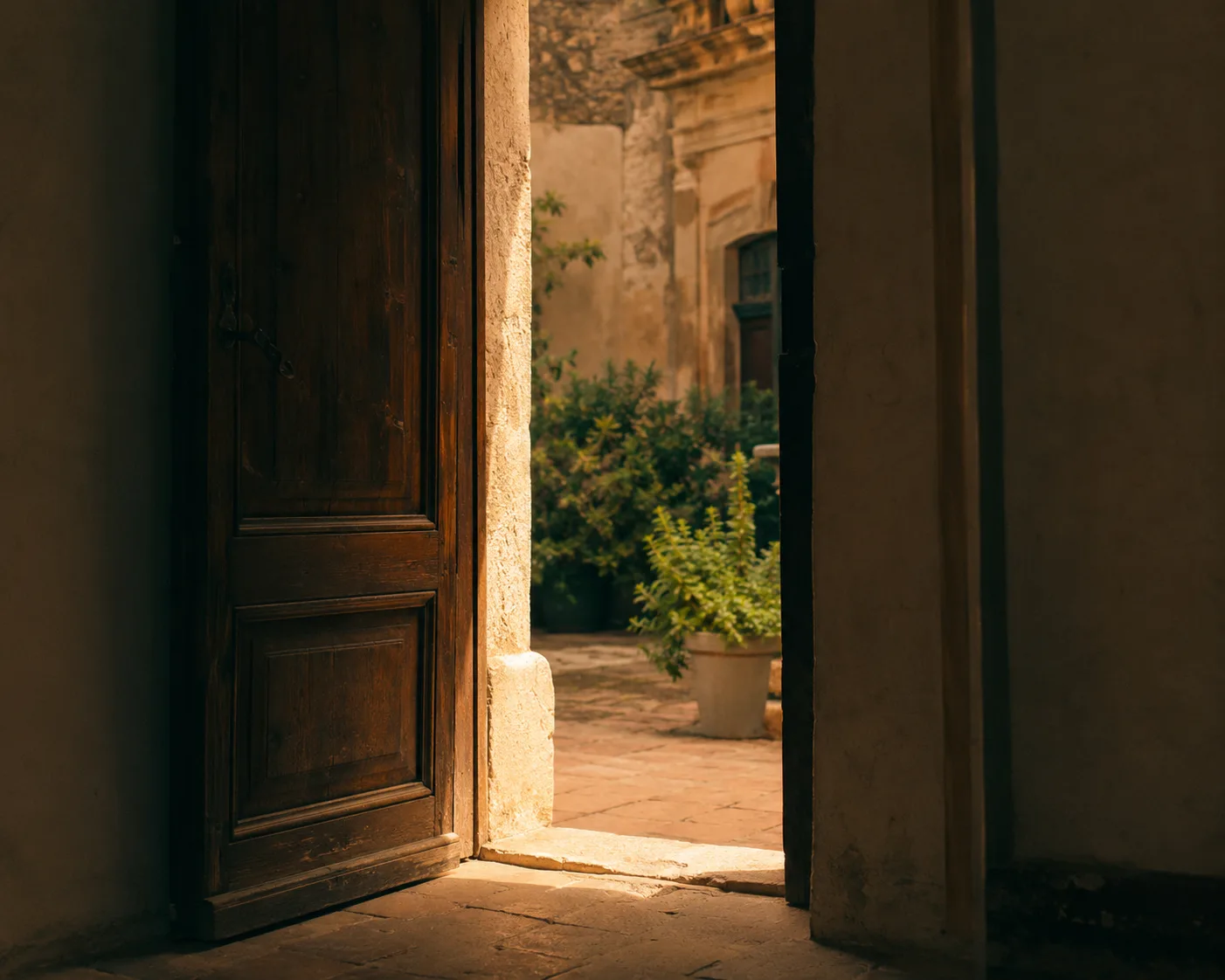 Una puerta entreabierta hacia un patio soleado en el centro histórico de Palermo, la calidez de una bienvenida en persona