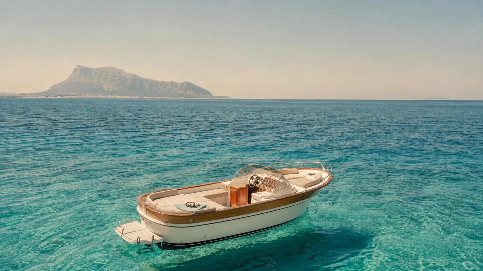 Un bateau dérivant sur une eau turquoise au large de la côte de Palerme